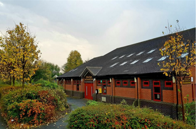 Exterior of St Peter's church Glascote Heath, a single-story red brick building with steep and high tiled roof