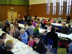 A social event at St Peter's Glascote Heath with long tables and people say ready to eat together