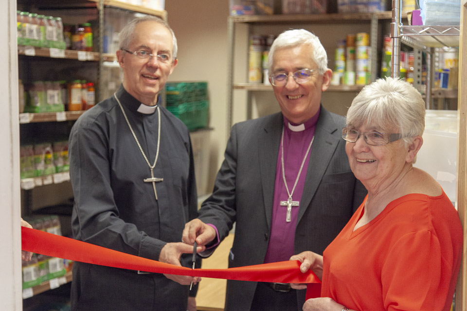 Archbishop Justin Welby, Bishop Michael Ipgrave and ... cut the ribbon for the newly enlarged foodbank at Burton YMCA